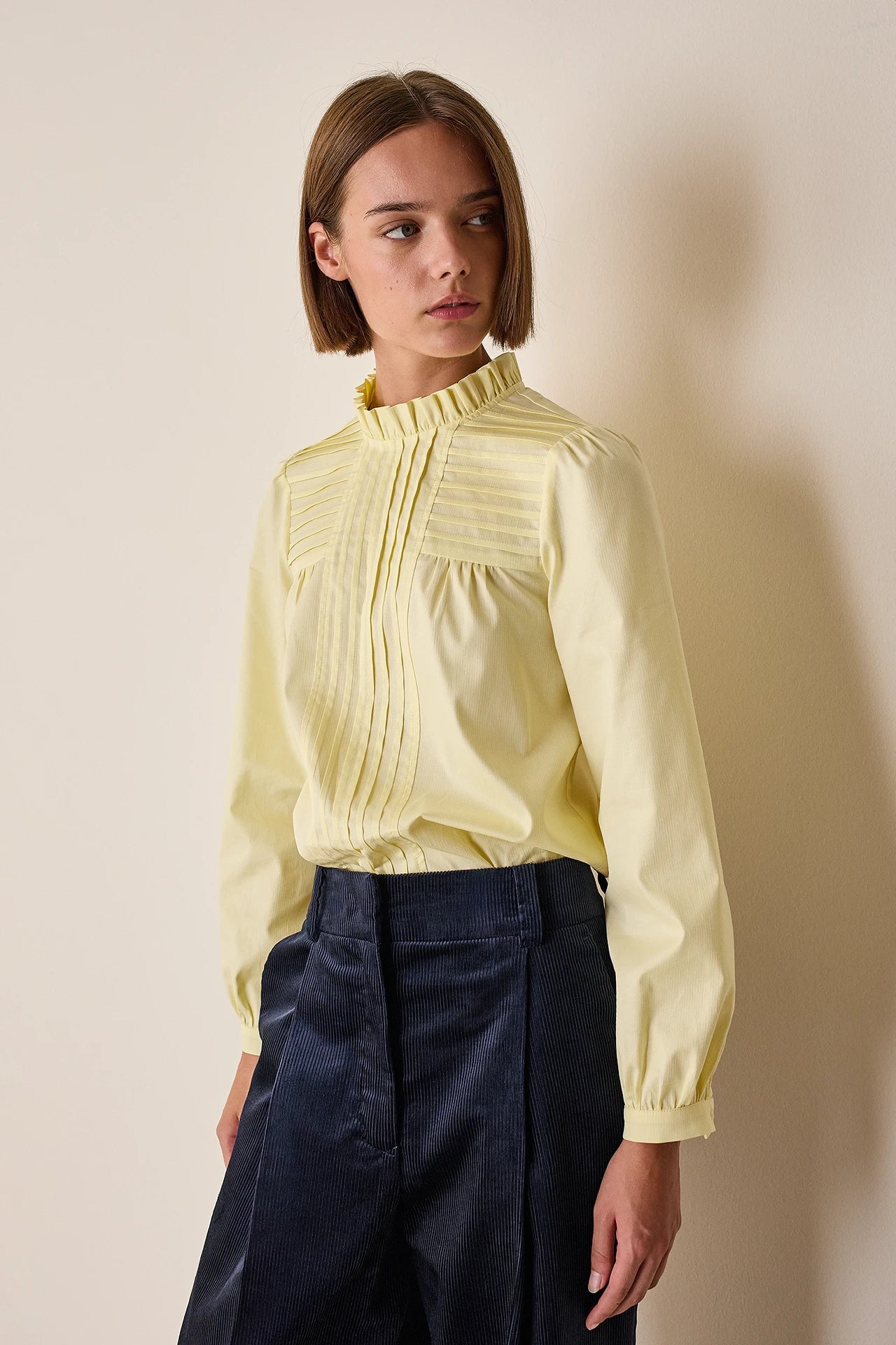 Top con piegoline e colletto volant