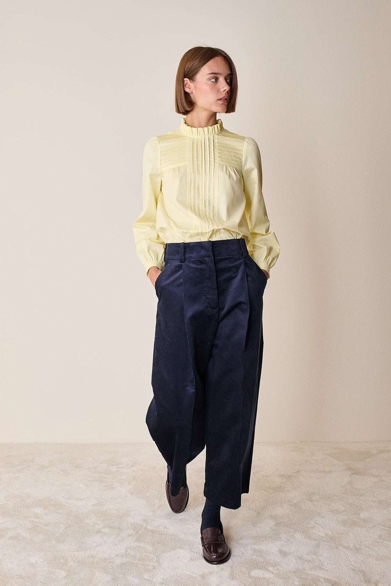 Top con piegoline e colletto volant