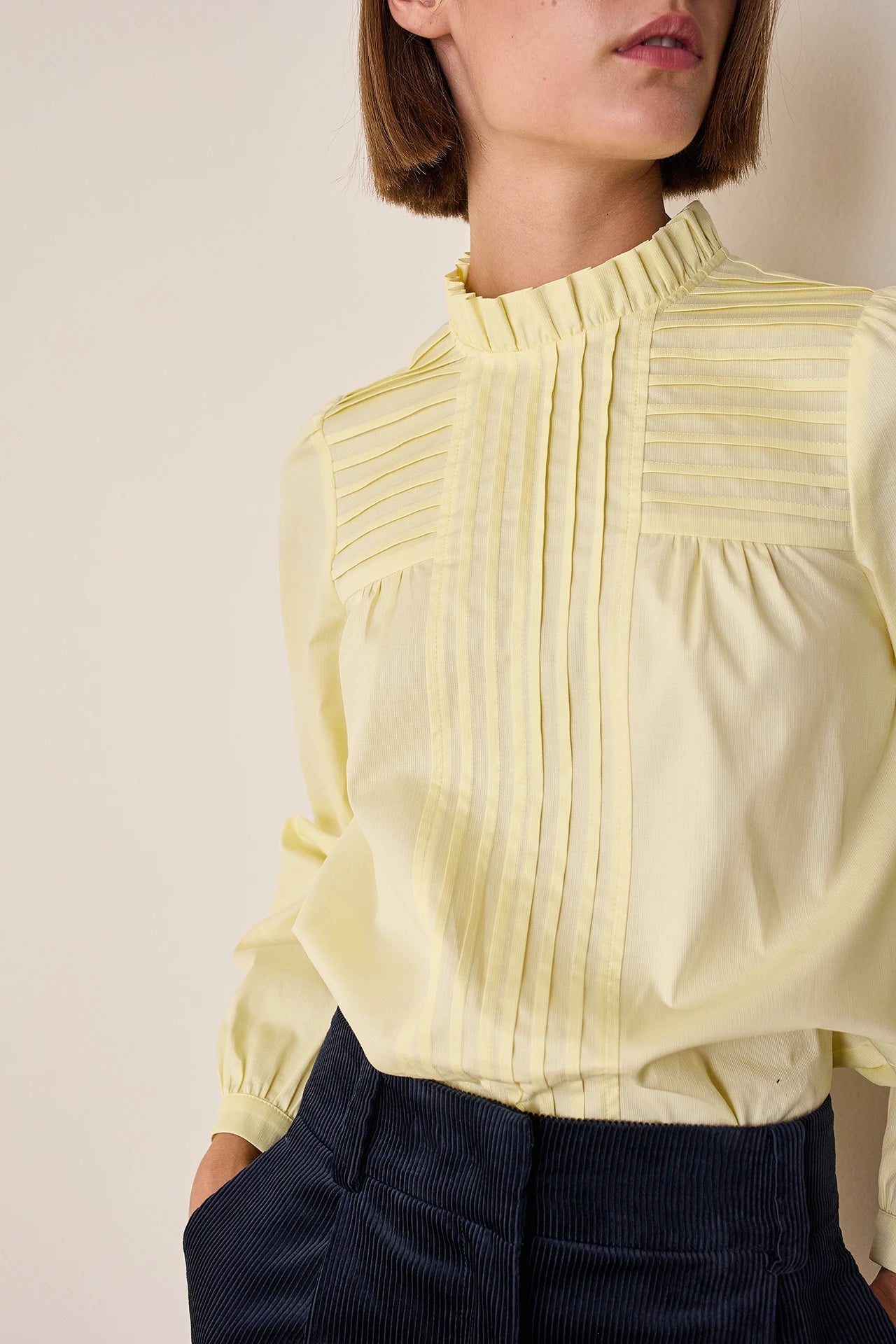 Top con piegoline e colletto volant