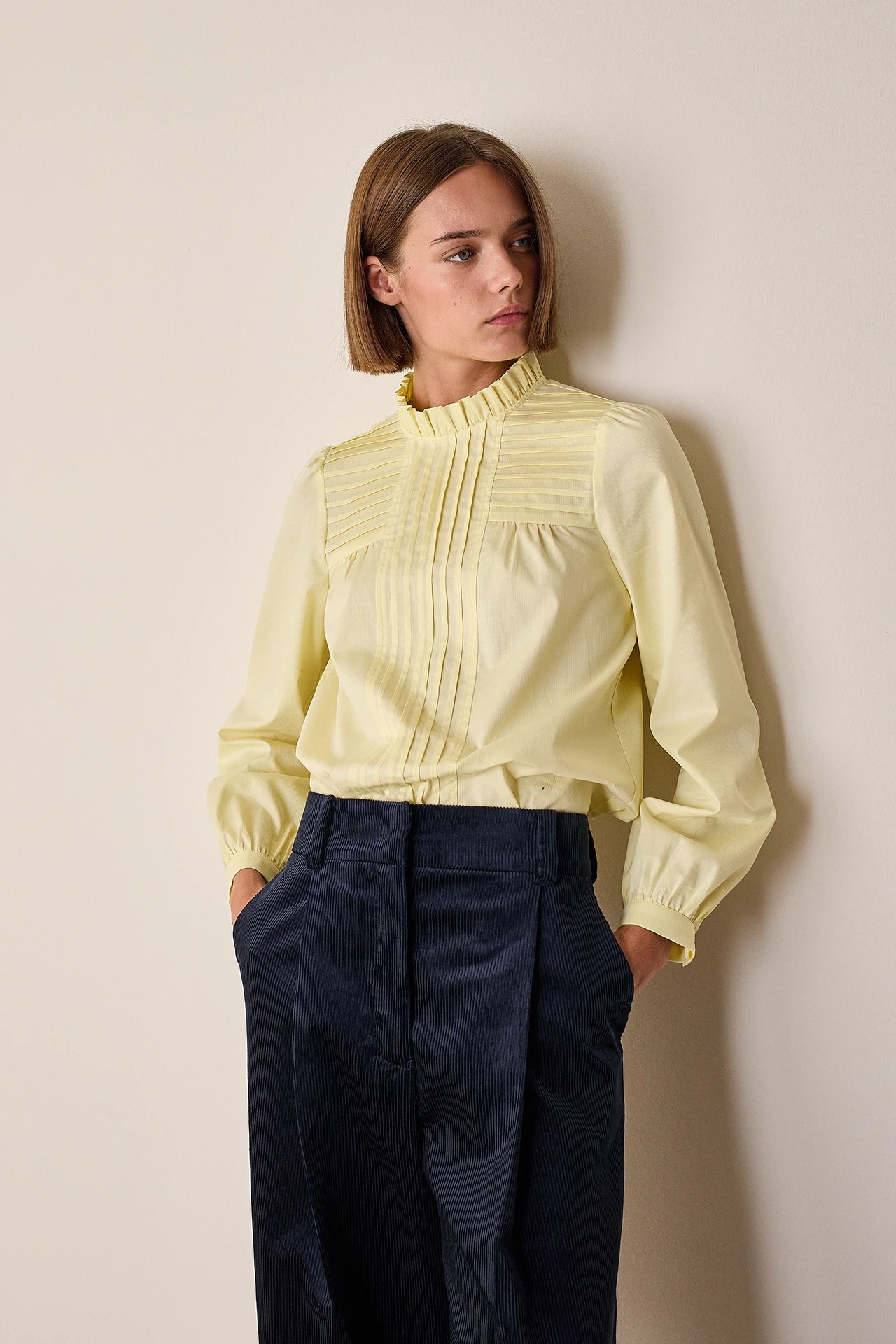 Top con piegoline e colletto volant