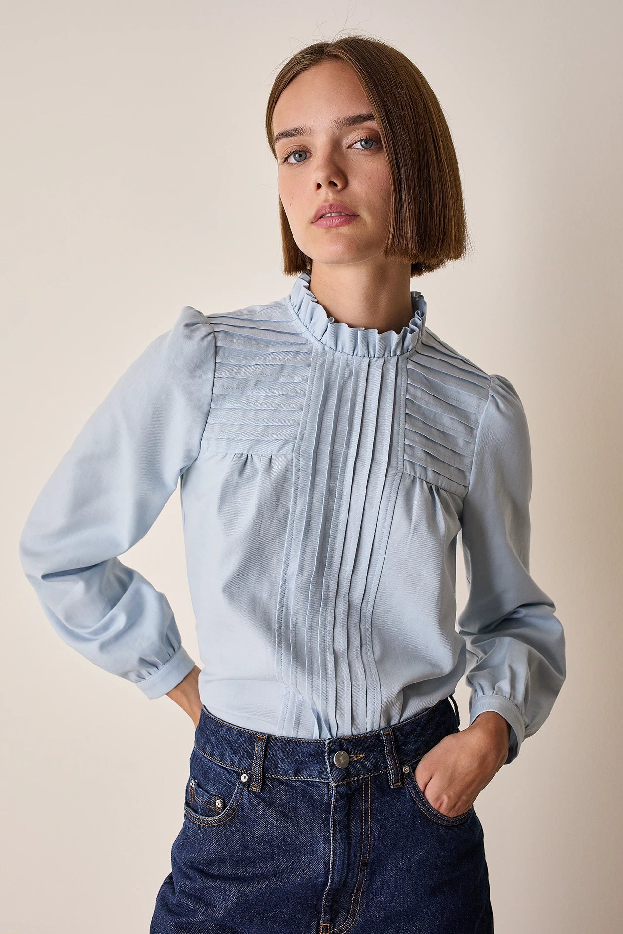 Top con piegoline e colletto volant