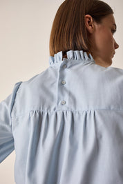 Top con piegoline e colletto volant